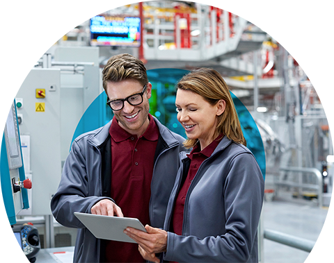 two people in a warehouse looking at an ipad